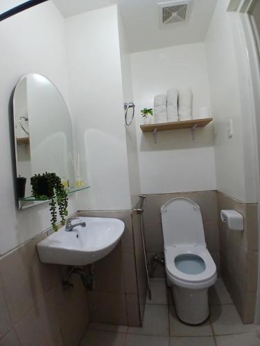 a bathroom with a toilet and a sink and a mirror at camella northpoint condominium close to airport,sm lanang,abreeza mall,spmc,dmsf,usep in Davao City