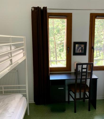 a bedroom with a desk and a bed and a chair at Adrechas Mercantour in La Colmiane