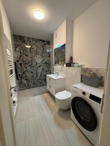 a bathroom with a toilet and a stone wall at Central monarch 1 P&P Residence in Timişoara