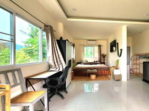 ein Schlafzimmer mit einem Bett, einem Schreibtisch und einem Stuhl in der Unterkunft Kopan House View point in Thongsala