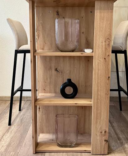 a wooden shelf with bowls and a vase on it at Apartman Nota in Vinkovci