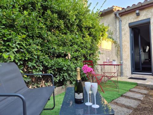 Studio Balnéo Bord de mer Fouras - 800m de la plage في فورا: طاولة مع زجاجة من النبيذ وكأسين