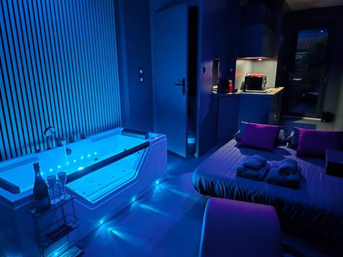 Studio Balnéo Bord de mer Fouras - 800m de la plage في فورا: غرفة زرقاء مع حوض استحمام وسرير