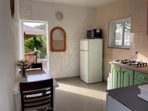 a kitchen with a white refrigerator and a table at Finca Chigora nice rural house near Los Gigantes Sun Room in Santiago del Teide
