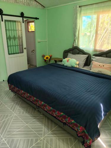 a large bed with a blue comforter in a bedroom at RATTHANATHON Farm in Khao Kho