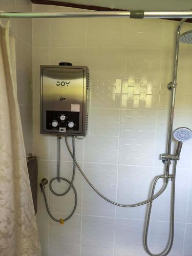 a shower with a soap dispenser in a bathroom at RATTHANATHON Farm in Khao Kho