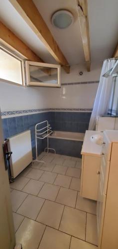 Un baño con lavabo y suelo de baldosas. en Villa Béa, en Filolie