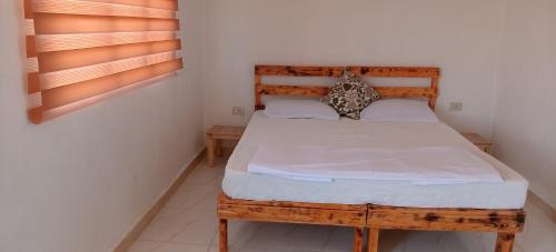 a bedroom with a wooden bed in a room at Alnwatif Gate guest house Dana nature reserve in Dana