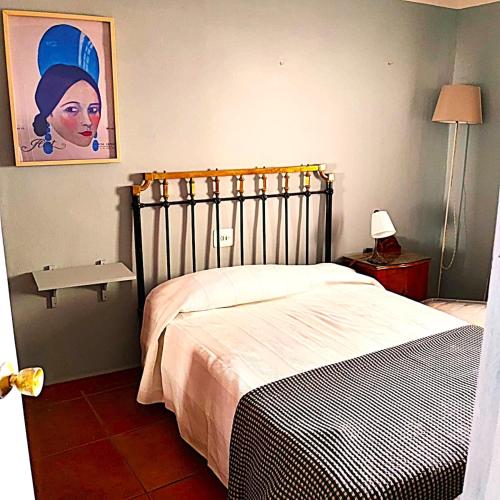 a bedroom with a bed and a picture on the wall at Hermosa Mía in Villaescusa de Haro