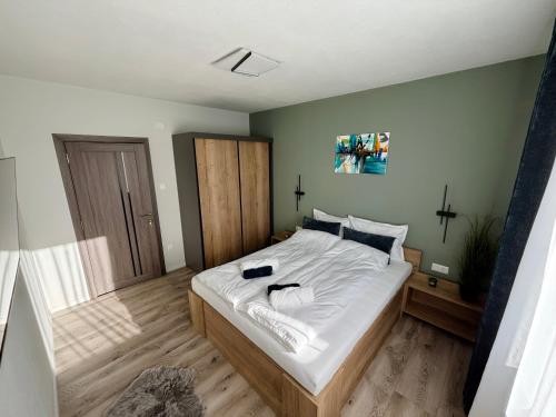 a bedroom with a large bed with white sheets at Forest Lux Apartman in Odorheiu Secuiesc