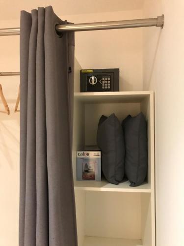 a shelf with a curtain and a box on it at Studio à la vallée heureuse in Sorède