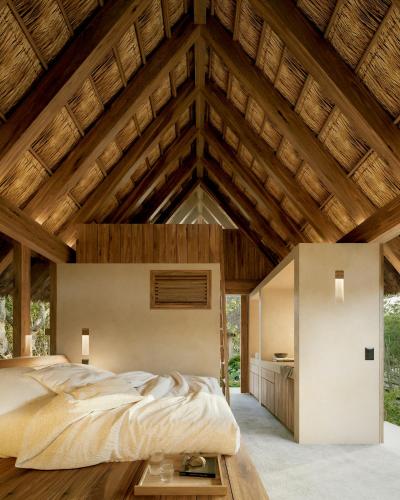 a bedroom with a large bed and a wooden ceiling at Casa Xul in Tulum