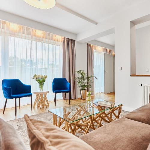 a living room with a couch and blue chairs at West Baltic Resort Wellness & Spa in Świnoujście