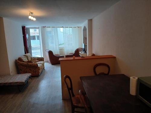 a living room with a table and chairs at Appartement entier in Montmarault