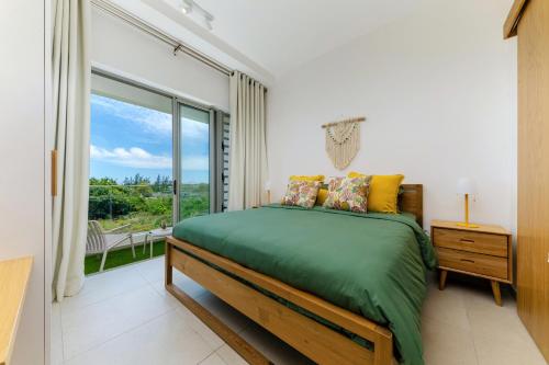 a bedroom with a bed and a large window at Tropica Bliss in Grand-Baie