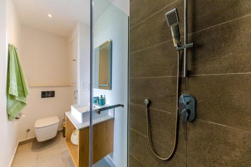 a bathroom with a shower with a toilet and a sink at Tropica Bliss in Grand-Baie