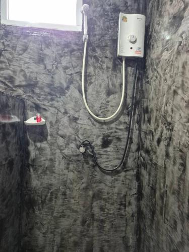 a shower in a bathroom with a stone wall at Poonsap Resort in Ko Lanta