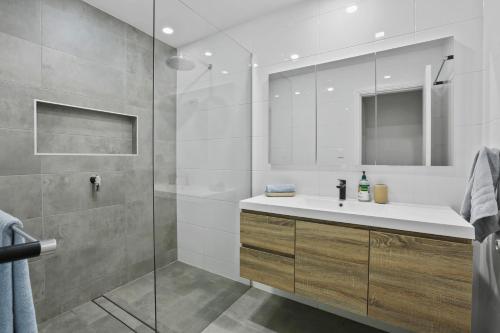 凯阿玛Kiama Beach Retreat - Big Yard & Movie Lounge的浴室配有洗手池和玻璃淋浴房