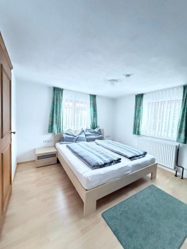 ein Schlafzimmer mit einem großen Bett und zwei Fenstern in der Unterkunft Apartment Juen in Tobadill