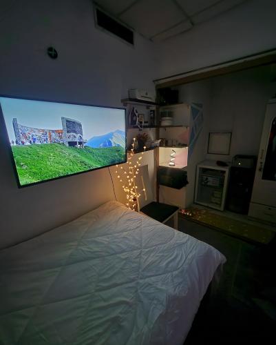 a bedroom with a large flat screen tv above a bed at DIGITAL OUMMAH RESIDENCEs 01 TCA in Abu Dhabi