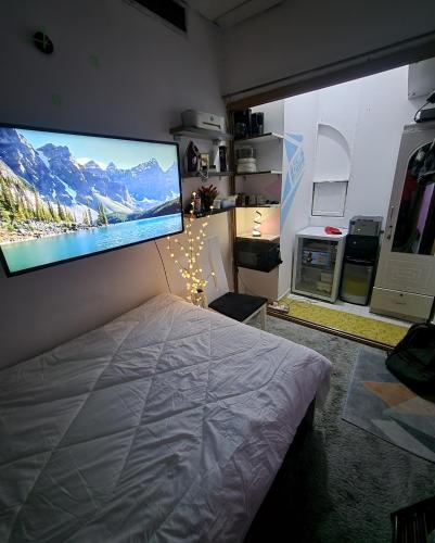 a bedroom with a large flat screen tv on the wall at DIGITAL OUMMAH RESIDENCEs 01 TCA in Abu Dhabi