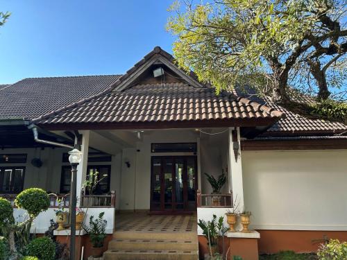 een klein huis met een bruin dak bij Teak Garden Resort, Chiang Rai in Chiang Rai