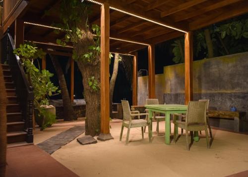 una mesa verde y sillas bajo un árbol en La Veranda Di Serena, en Unawatuna