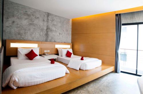 a bedroom with two beds with red pillows at The Now Hotel - SHA Extra Plus in Jomtien Beach