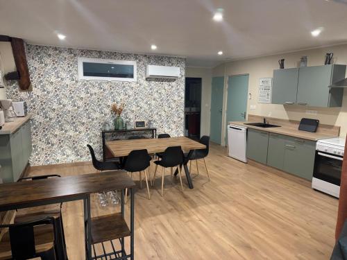 eine Küche mit Tisch und Stühlen in einem Zimmer in der Unterkunft L Appart du Suran 