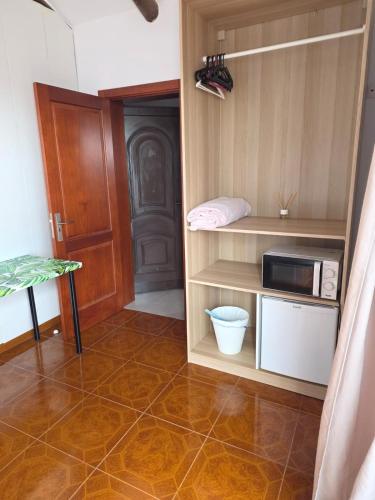 a small room with a microwave and a kitchen at El sueño - Le rêve in San Bartolomé