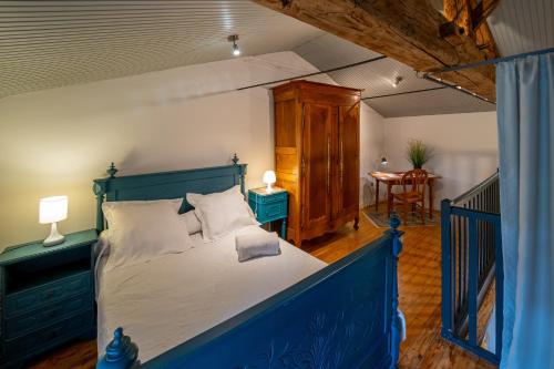 Grand-LandesGite de l'Hubertiere的一间卧室配有一张蓝色的床和一张桌子