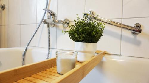 een glas melk en een plant op een houten plank in een badkamer bij Apartment am Golfplatz in Mackenbach in Mackenbach