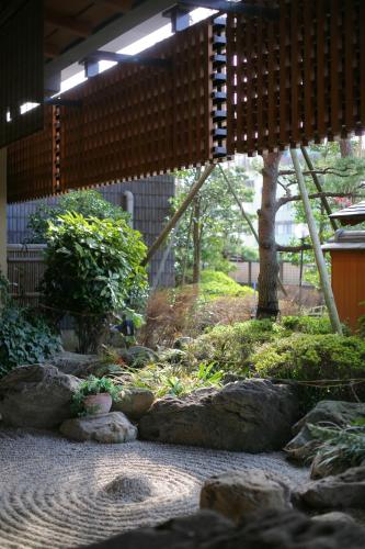 a garden with rocks and trees and a building at Grandia Housen in Awara