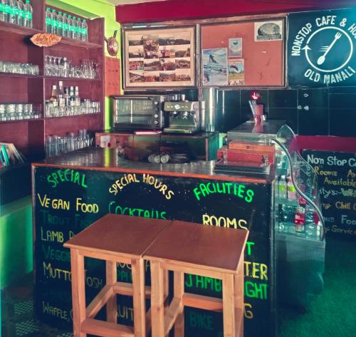 a bar with a wooden table in a restaurant at Non Stop Cafe Hostel & Stay in Manāli