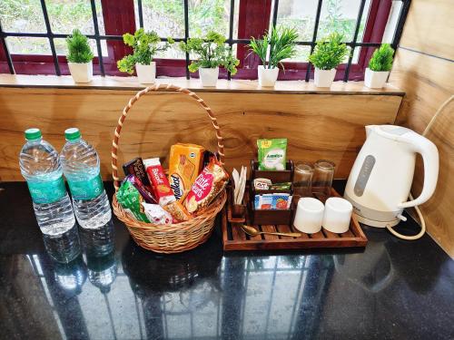 una cesta de comida y botellas de agua en una mesa en Harichandhanam Inn - Entire Flat, Ground Floor, 200m From East Nada Guruvayur, en Guruvāyūr