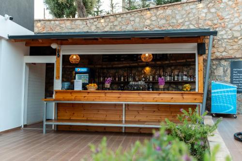 un bar en un edificio con una pared de madera en Hotel Memai Suites, en Ksamil
