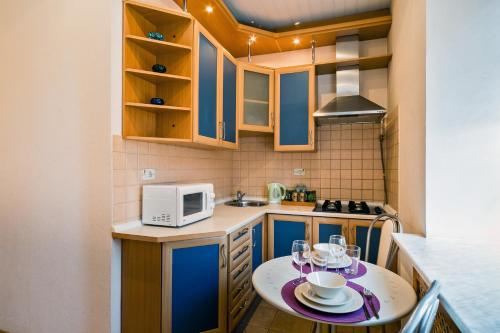モスクワにあるLux Apartment Berezhkovskaya Naberezhnaya, 4の小さなキッチン(ワイングラス付きのテーブル付)