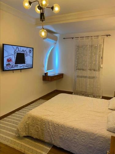 a bedroom with a bed and a tv on the wall at F3 Draria équipé Alger in Draria