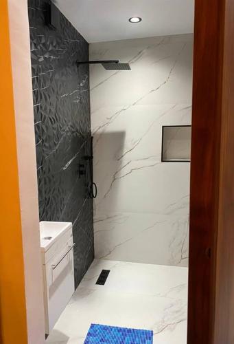 a bathroom with a shower with white marble walls at F3 Draria équipé Alger in Draria