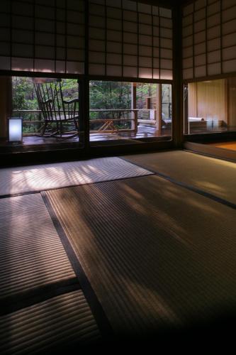 an empty room with windows and a wooden floor at Grandia Housen in Awara