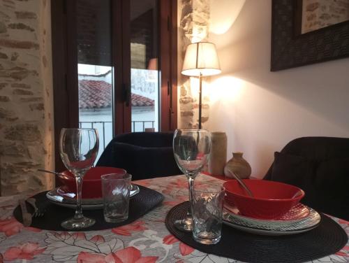 Una mesa con dos copas de vino y un cuenco encima. en Las Golondrinas, en Galaroza