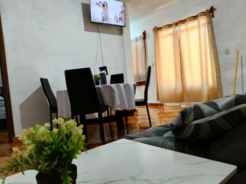 a living room with a table and a tv on the wall at Cerca de pirámides, bancos, centros, UDLA, paradas in Cholula