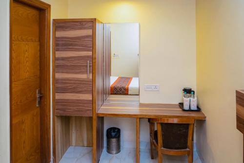 Camera con scrivania in legno e specchio. di Hotel Golden Oasis - 5 Minute Walk from New Delhi Railway Station a Nuova Delhi