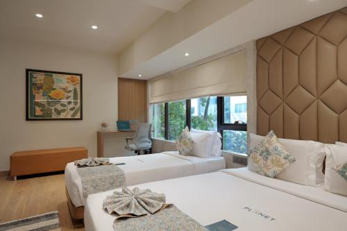 a hotel room with two beds and a window at Planet Boutique Hotel in Mumbai