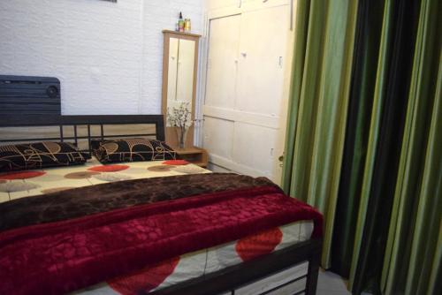 a bedroom with a bed with a red blanket on it at Men-only COZYCORNER in Lucknow