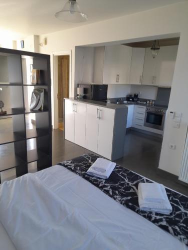 a kitchen with white cabinets and a bed in a room at Anesis Premium Living Ιωάννινα in Ioannina