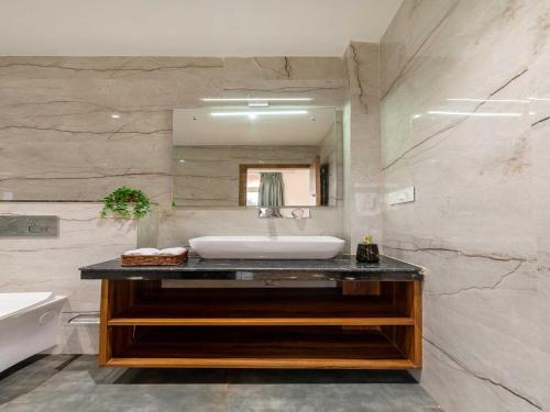 een badkamer met een wastafel en een spiegel bij Villa Aumentar by DanCenter in Arpora