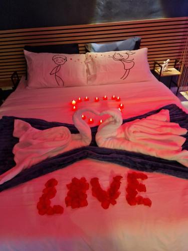een bed met twee zwanen gemaakt van rode rozen bij Love Room romantique avec jacuzzi - Arles centre in Arles