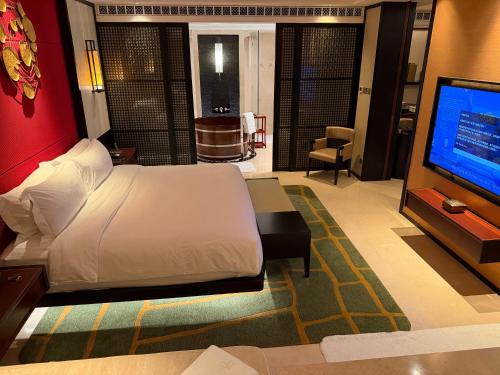 ein Schlafzimmer mit einem Bett und einem Flachbildfernseher in der Unterkunft 澳门高奢酒店套房特价一折起预定 in Macau