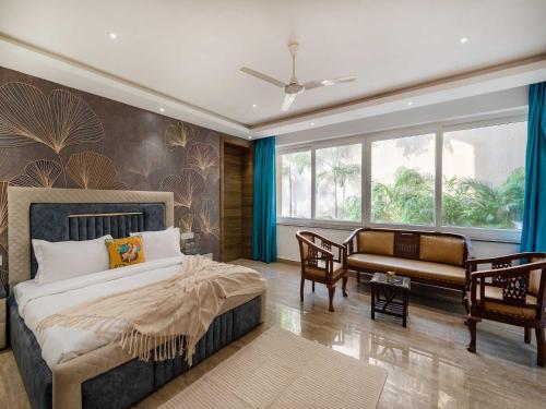 een slaapkamer met een bed en een bank erin bij Villa Aumentar by DanCenter in Arpora